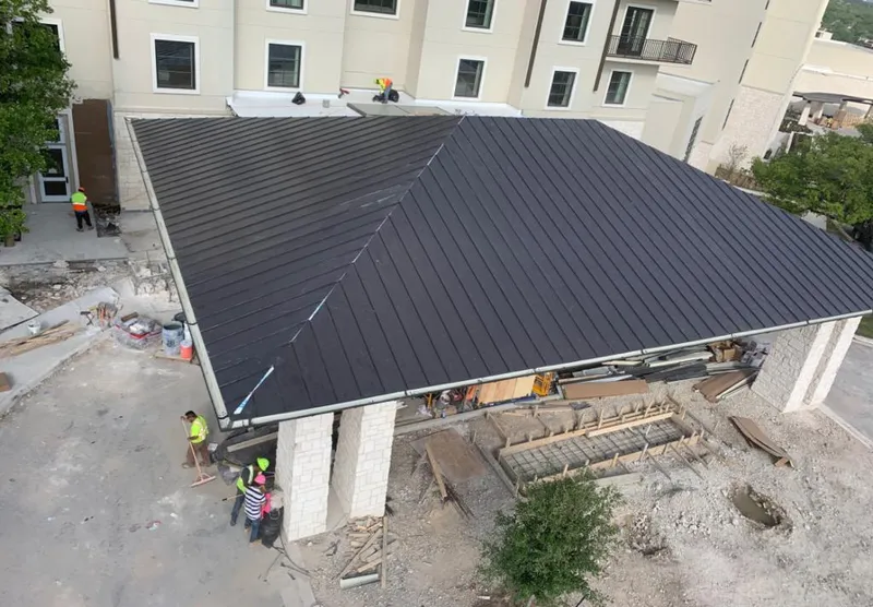 Metal roofing installation team working on a commercial building in Jamestown